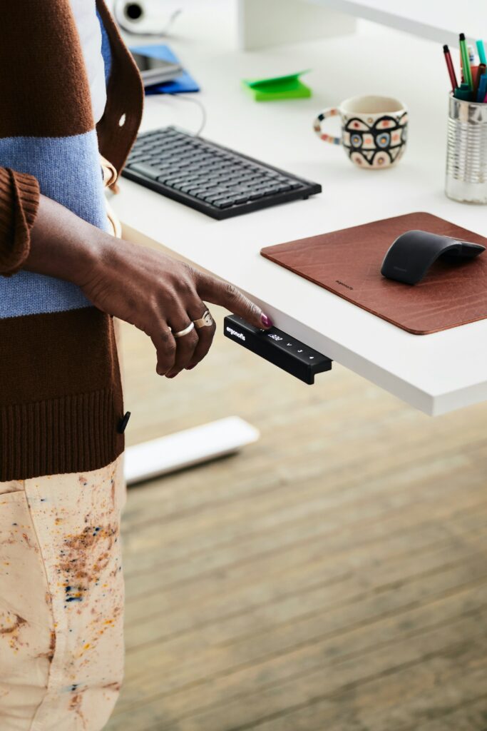 Electric sit-to-stand desk frame, motor, and height controller detail